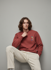 Man wearing a red sweatshirt with colorful graphic
