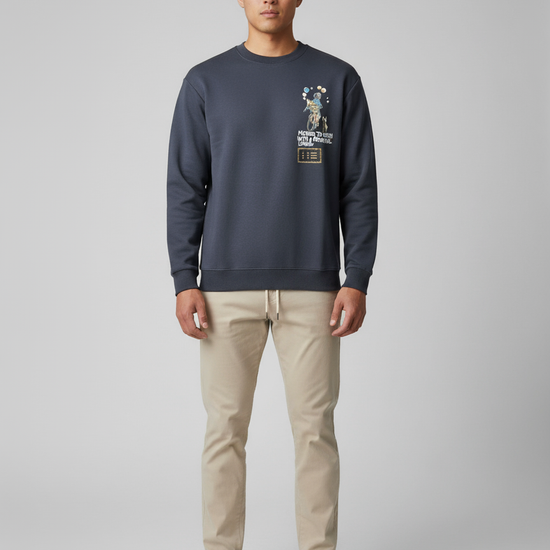 Man wearing a navy sweatshirt with a printed and embroidered design
