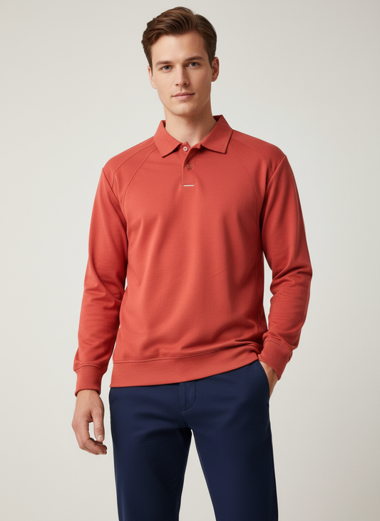 Man wearing a red long-sleeve polo shirt and blue pants on a light background